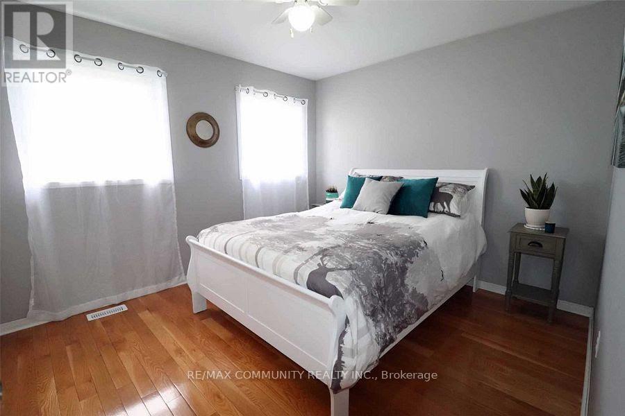 A bedroom with a bed, nightstand, and window with curtains.