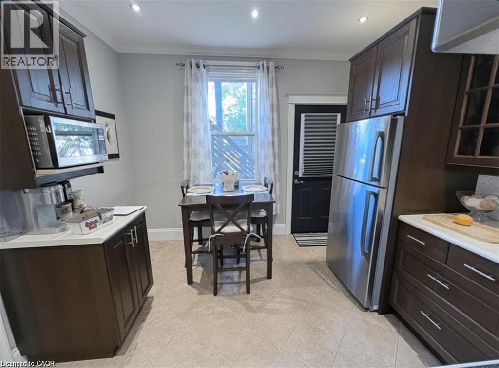 A kitchen with a refrigerator, microwave, and a table with chairs.