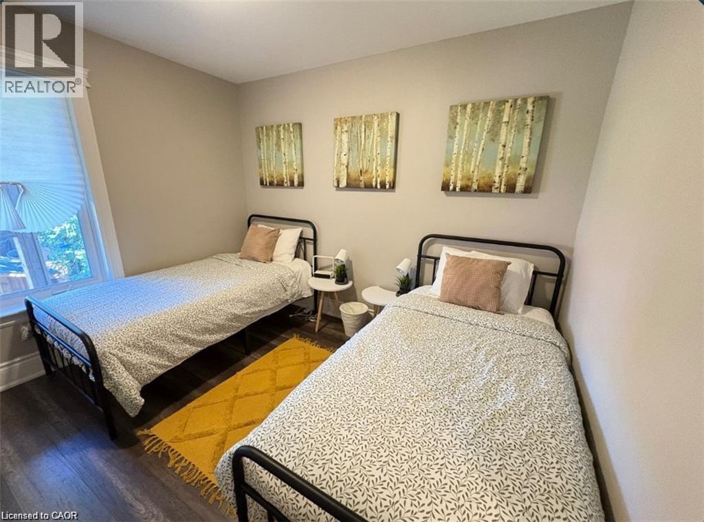 A bedroom with two beds and two nightstands.