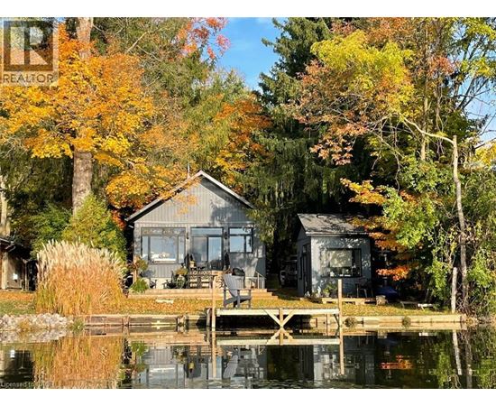 A house is surrounded by trees with autumn leaves.