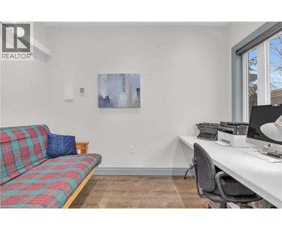 A living room with a plaid couch and a desk with a computer.