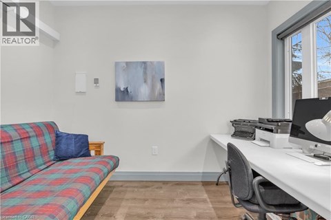 A living room with a plaid couch and a desk with a computer.