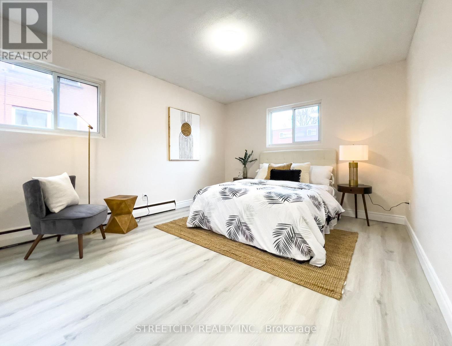 A bedroom with a bed, chair, and lamp.