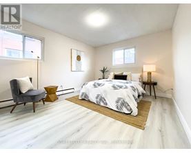A bedroom with a bed, chair, and lamp.