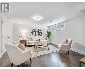 A living room with a white sofa, two white chairs, and a coffee table.