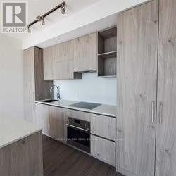 A kitchen with wooden cabinets and a stainless steel sink.