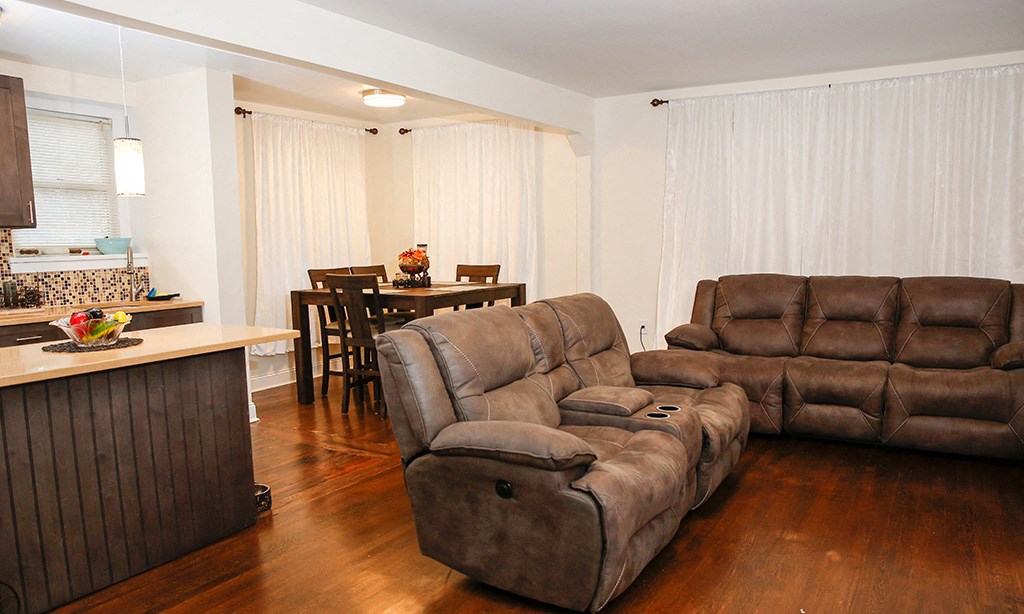 a living room and dining room with couches and a table