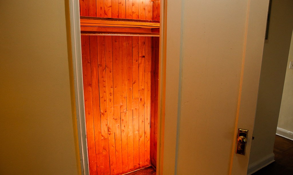 a closet with a wooden door and an orange light in it