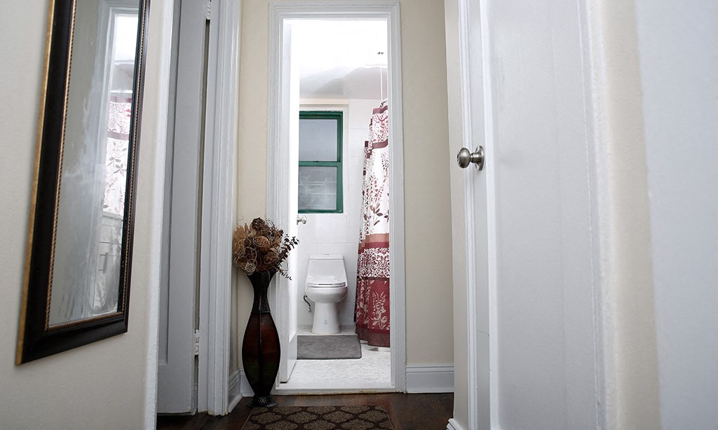 a small bathroom with a toilet and a red and white shower