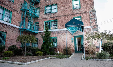 a brick building with a green door and a sign that reads marshall office