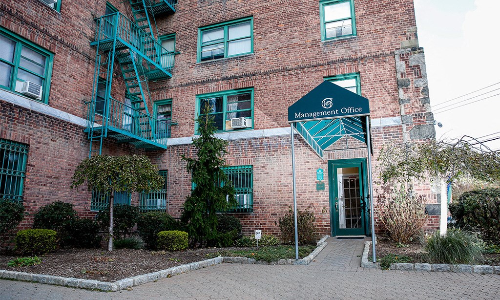 a brick building with a green door and a sign that reads marshall office