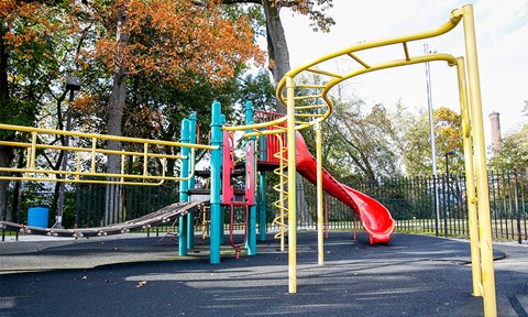 a playground with a red slide in a park