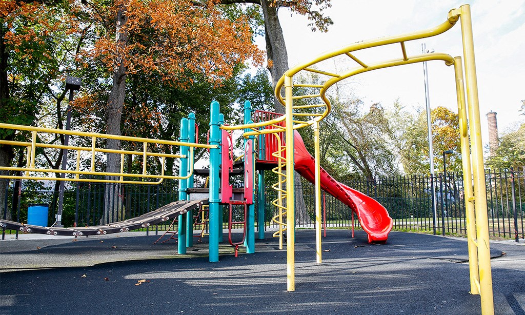 a playground with a red slide in a park