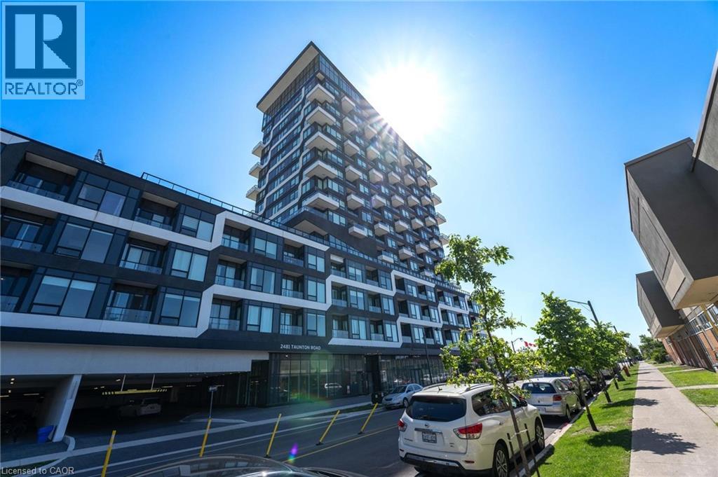 A modern building with a glass facade stands tall in the sunlight.