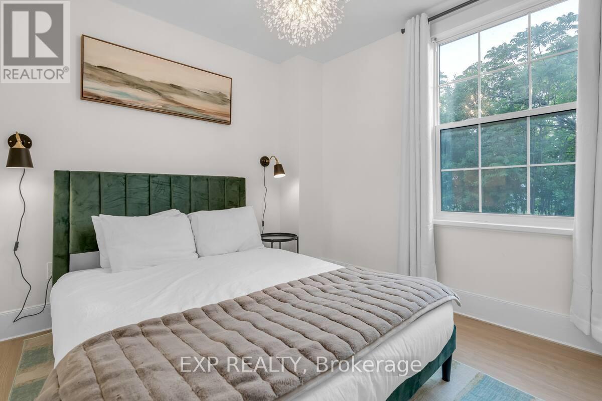 A bedroom with a large bed and a chandelier.