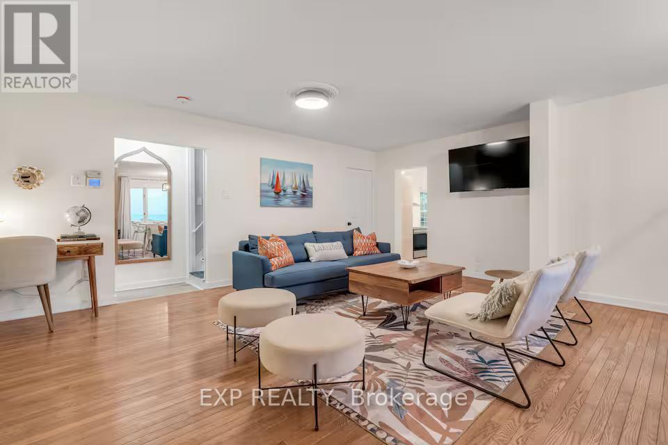 A living room with a blue couch and a wooden floor.