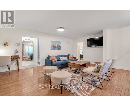 A living room with a blue couch and a wooden floor.