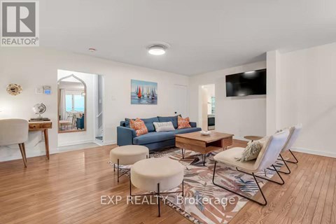 A living room with a blue couch and a wooden floor.