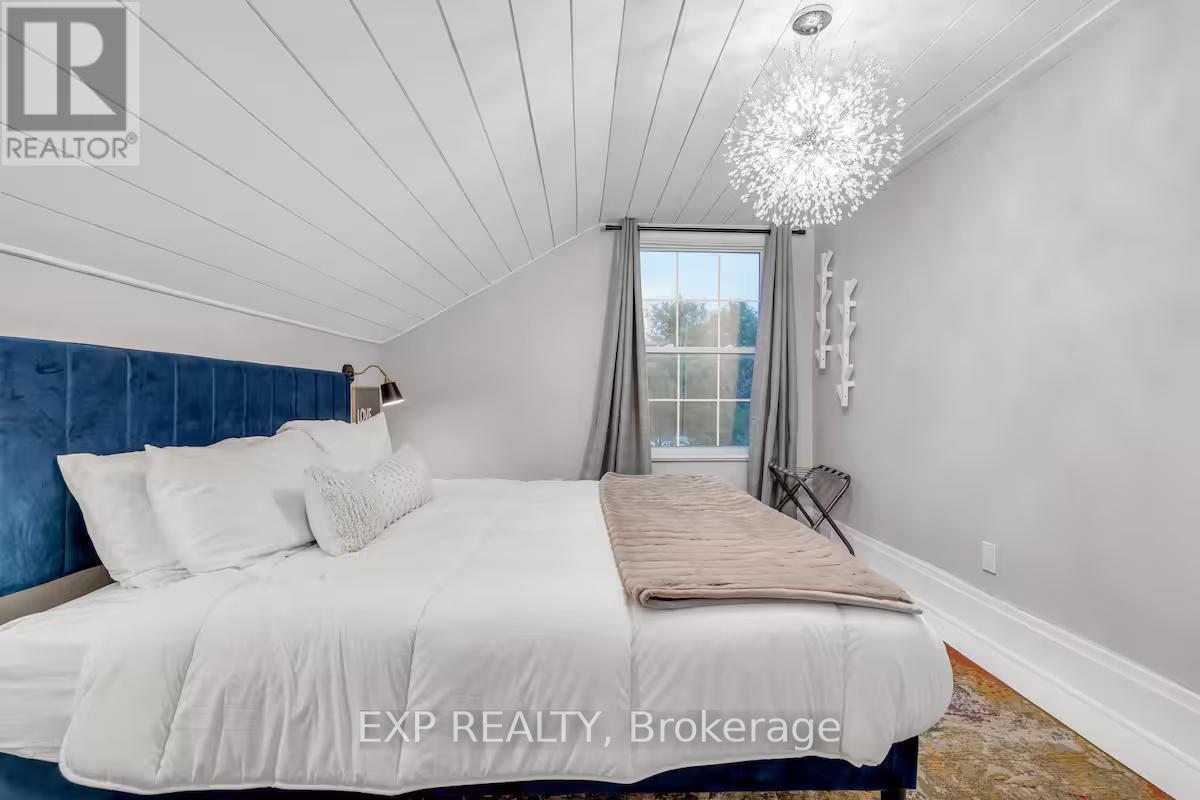 A bedroom with a large bed and a chandelier.