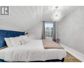A bedroom with a large bed and a chandelier.