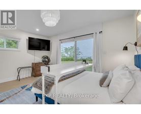 A bedroom with a large bed and a flat screen TV mounted on the wall.