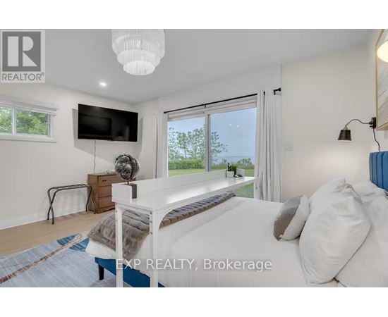 A bedroom with a large bed and a flat screen TV mounted on the wall.