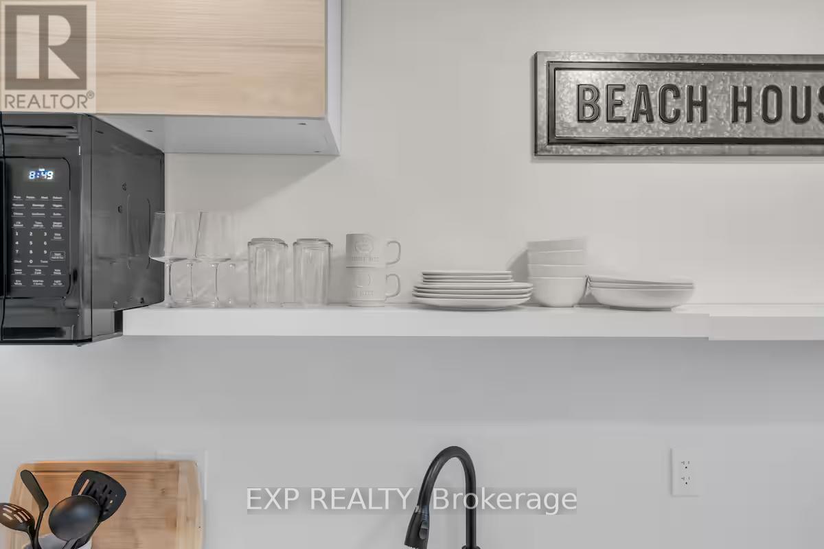 A kitchen counter with a sign that says "BEACH HOUSE" on the wall.