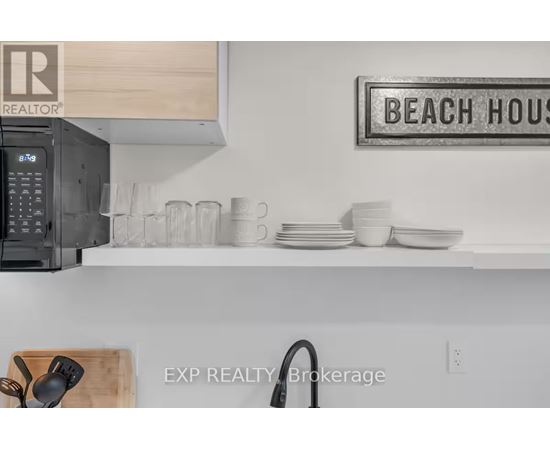 A kitchen counter with a sign that says "BEACH HOUSE" on the wall.