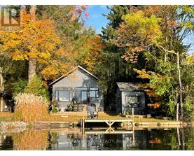 A house is situated on a lake surrounded by trees.