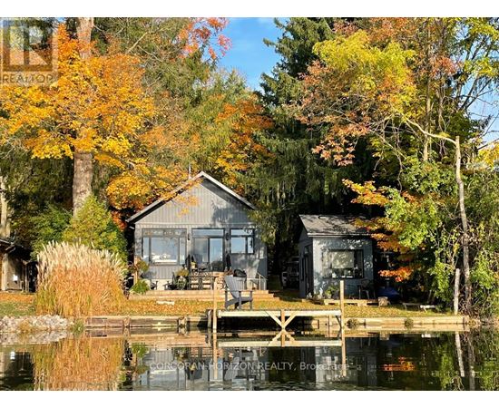 A house is situated on a lake surrounded by trees.