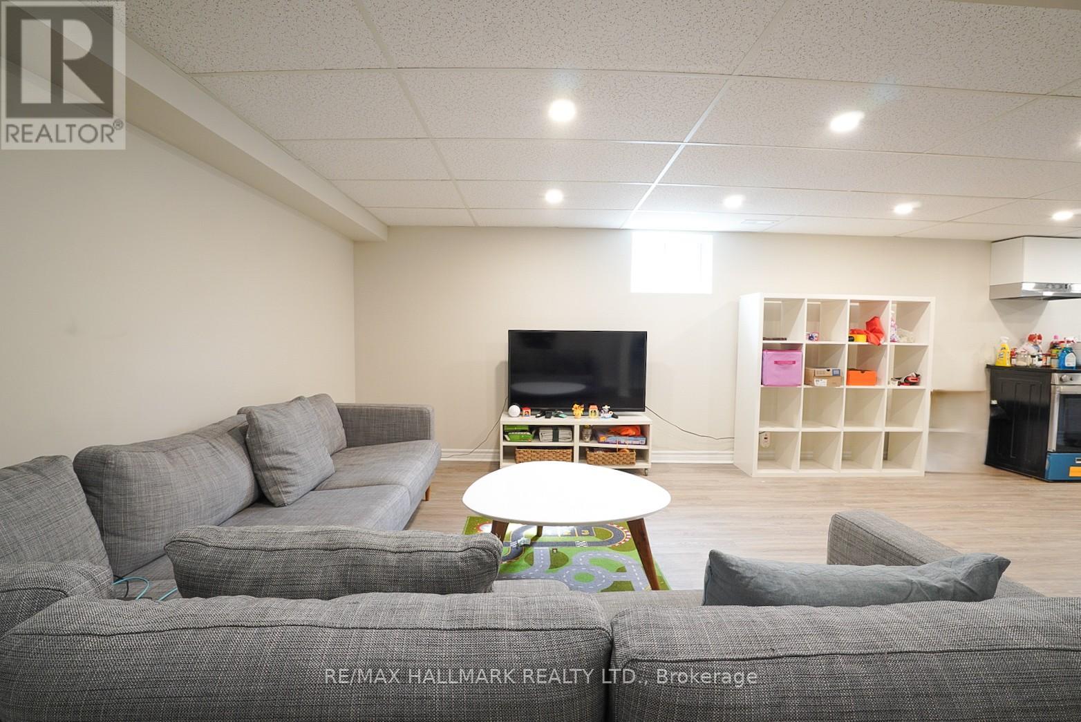 A living room with grey couches and a flat screen TV.