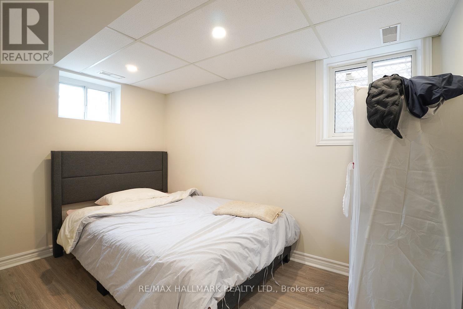 A bedroom with a bed, a window, and a wall-mounted coat rack.