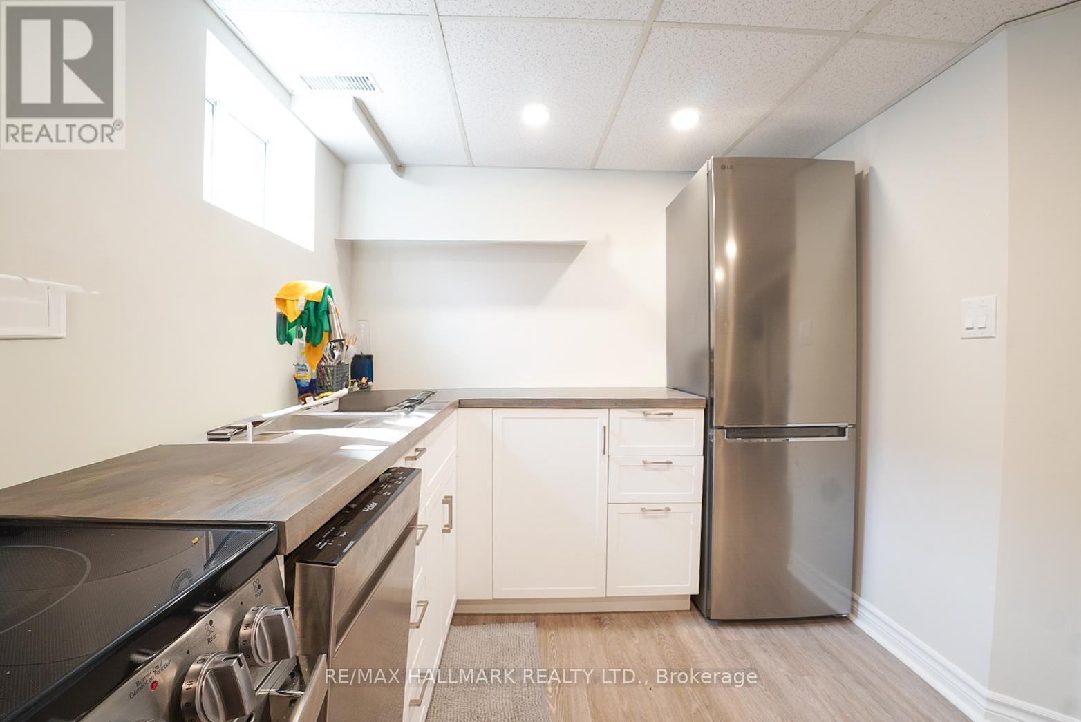 A kitchen with a stainless steel refrigerator and a stove top oven.