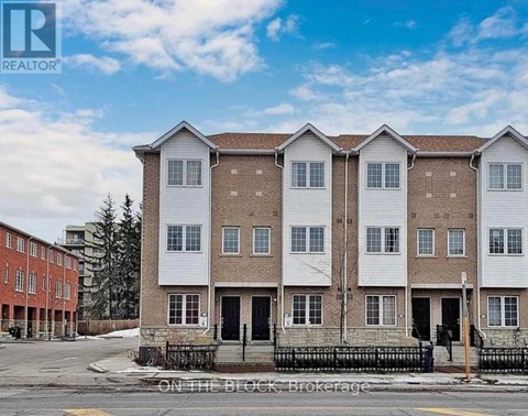 A row of townhouses with a sign that says "REALTOR" on the top left corner.