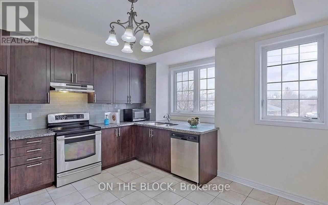 A kitchen with dark wood cabinets and stainless steel appliances is on the market.