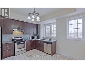 A kitchen with dark wood cabinets and stainless steel appliances is on the market.