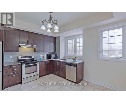 A kitchen with dark wood cabinets and stainless steel appliances is on the market.