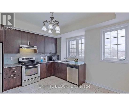 A kitchen with dark wood cabinets and stainless steel appliances is on the market.