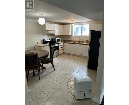 A kitchen with a table and chairs.