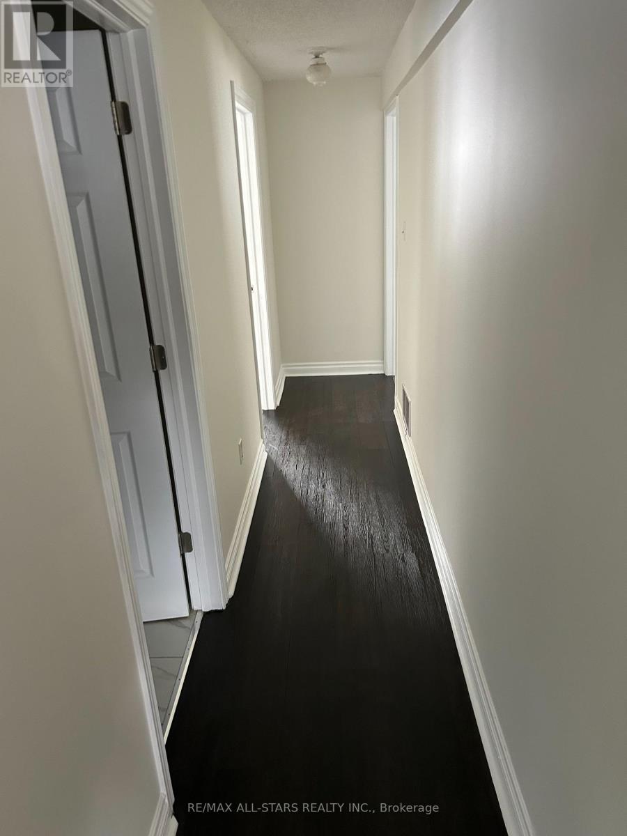 A hallway with a black floor and white walls.