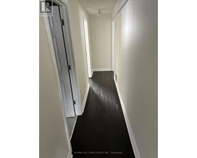 A hallway with a black floor and white walls.