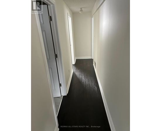 A hallway with a black floor and white walls.