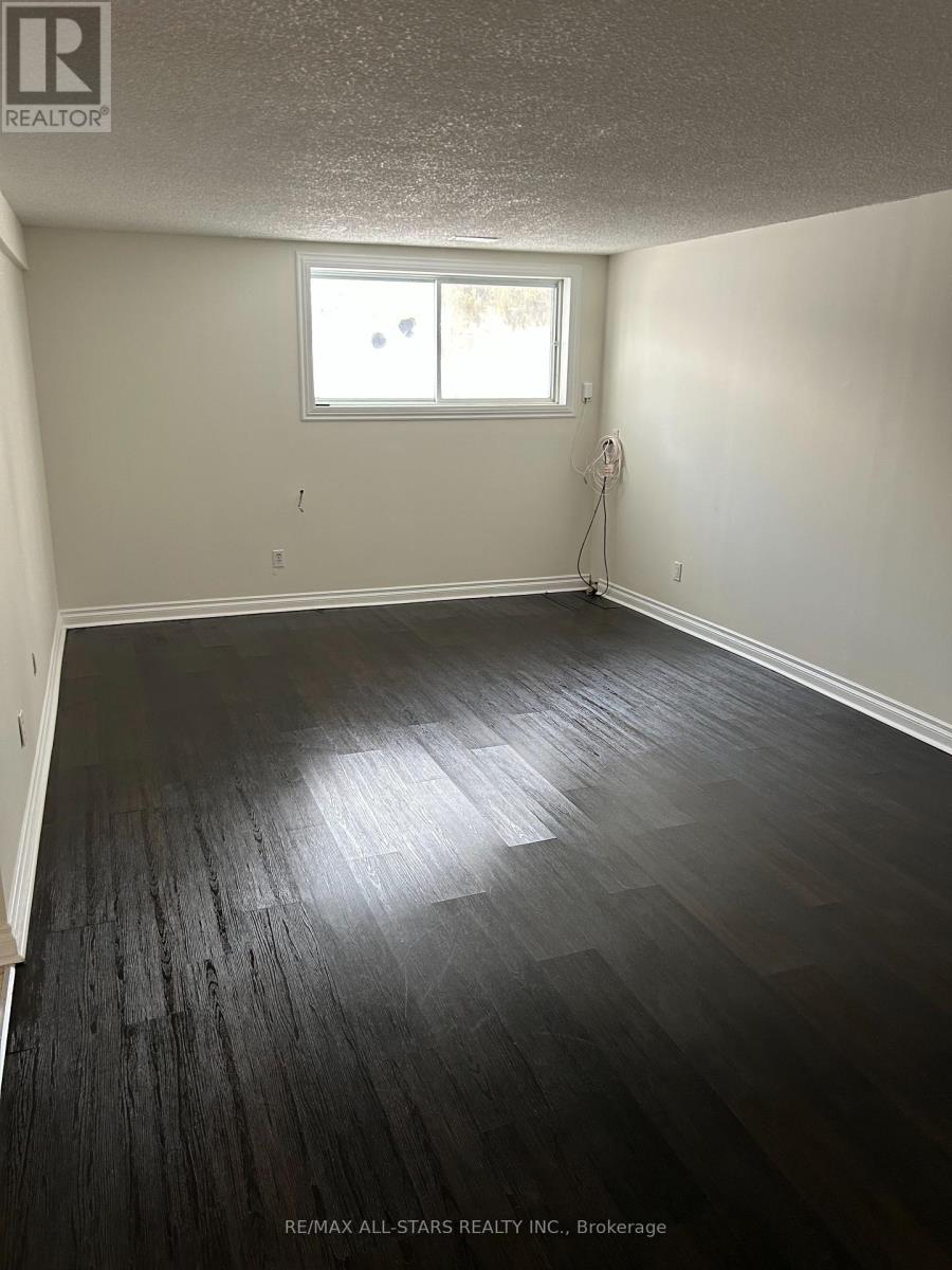 A room with a window and a wooden floor.