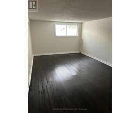 A room with a window and a wooden floor.