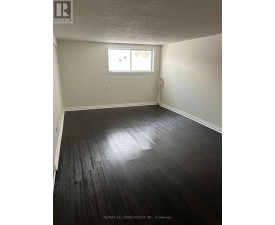 A room with a window and a wooden floor.