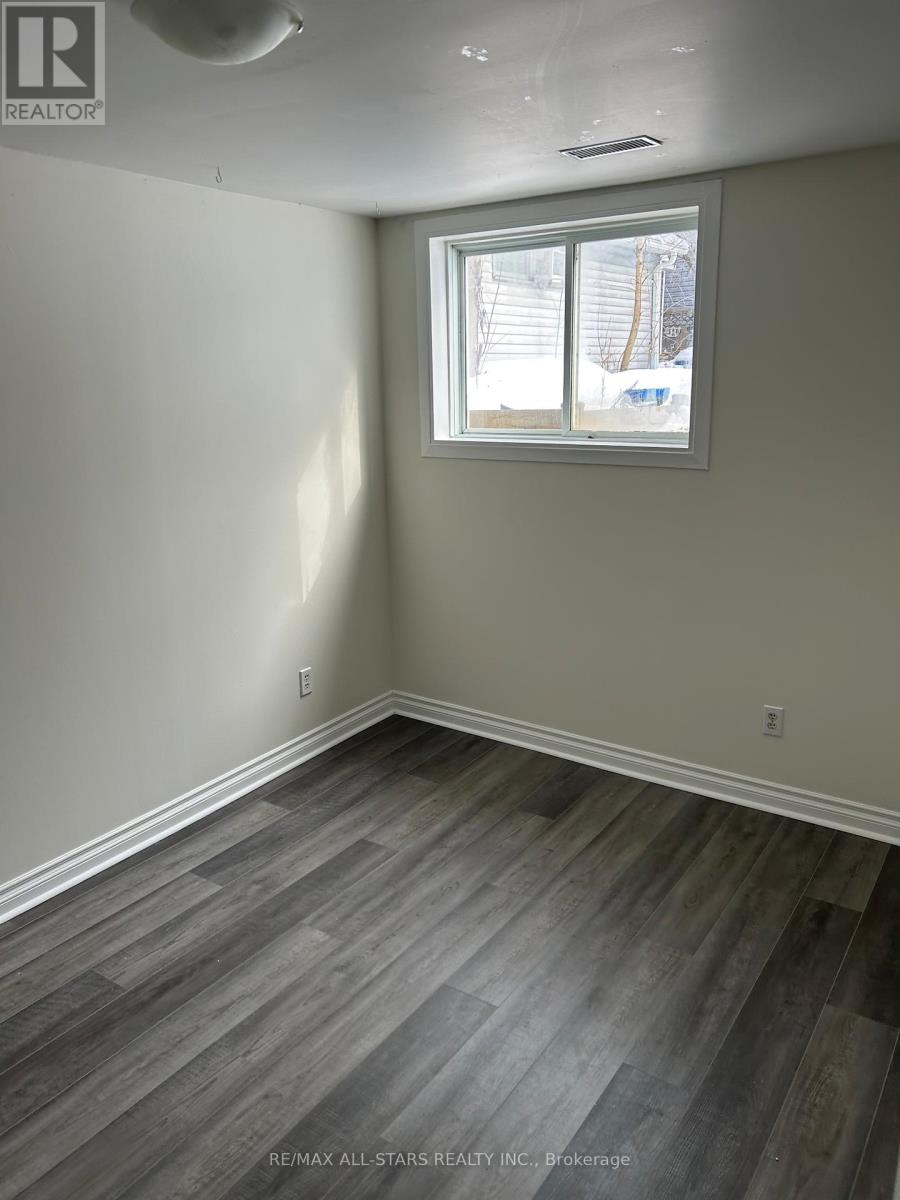 A room with a window and a wooden floor.