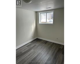 A room with a window and a wooden floor.