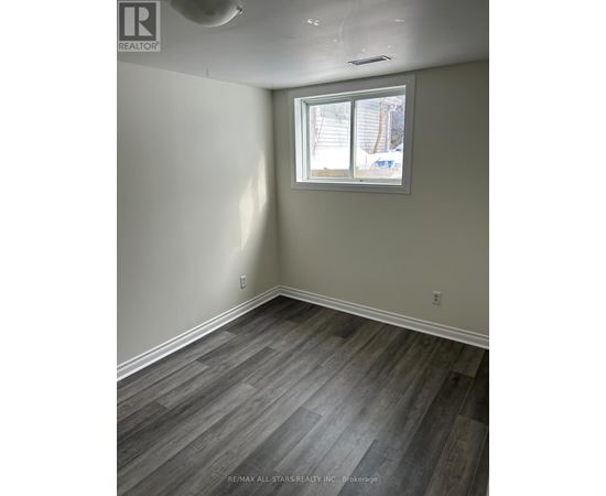 A room with a window and a wooden floor.