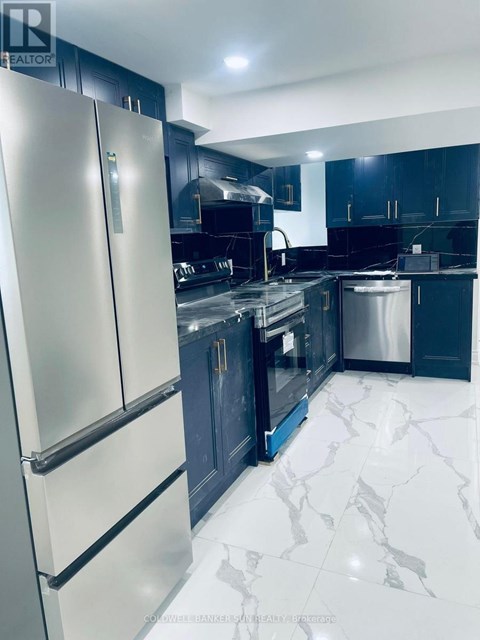 A modern kitchen with a white fridge and black cabinets.
