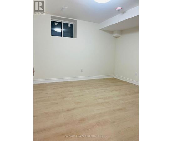 A room with a window and wooden flooring.